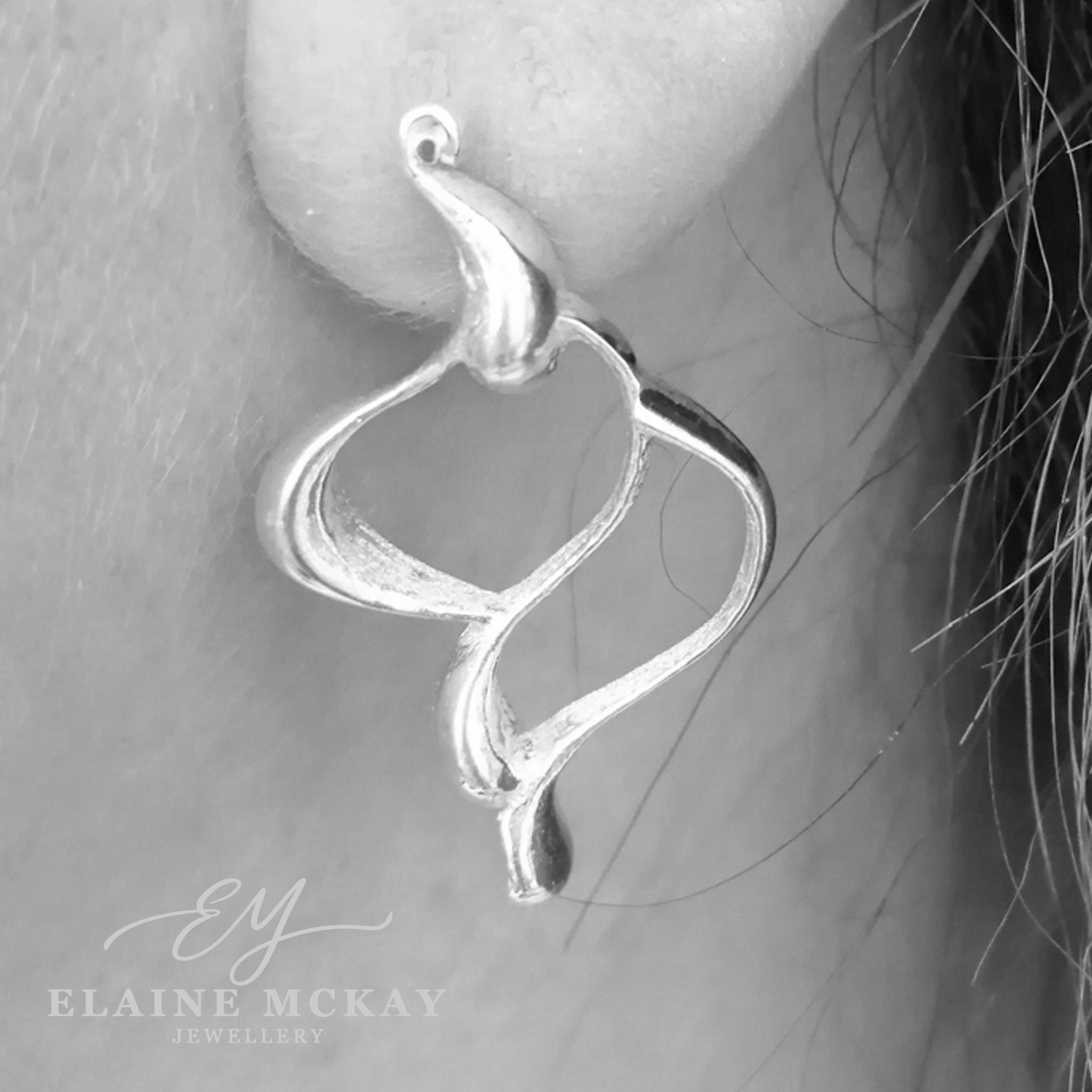 Silver earring worn on an ear with 'Elaine McKay Jewellery' branding.