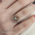 Silver ring with a central bullet shaped topaz gemstone on a person's finger, branded 'Elaine McKay Jewellery