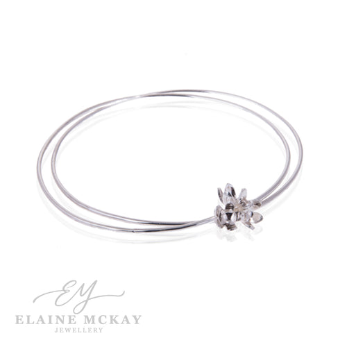 Silver bracelet with a floral clasp on a white background, branded 'Elaine McKay Jewellery'.