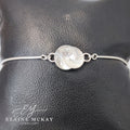 Silver bracelet with a circular design on a black leather surface, branded 'Elaine McKay Jewellery'.