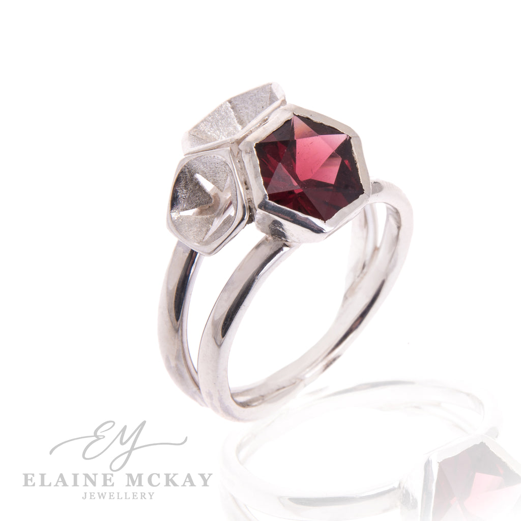 Silver ring with a red gemstone on a white background, branded 'Elaine McKay Jewellery'.