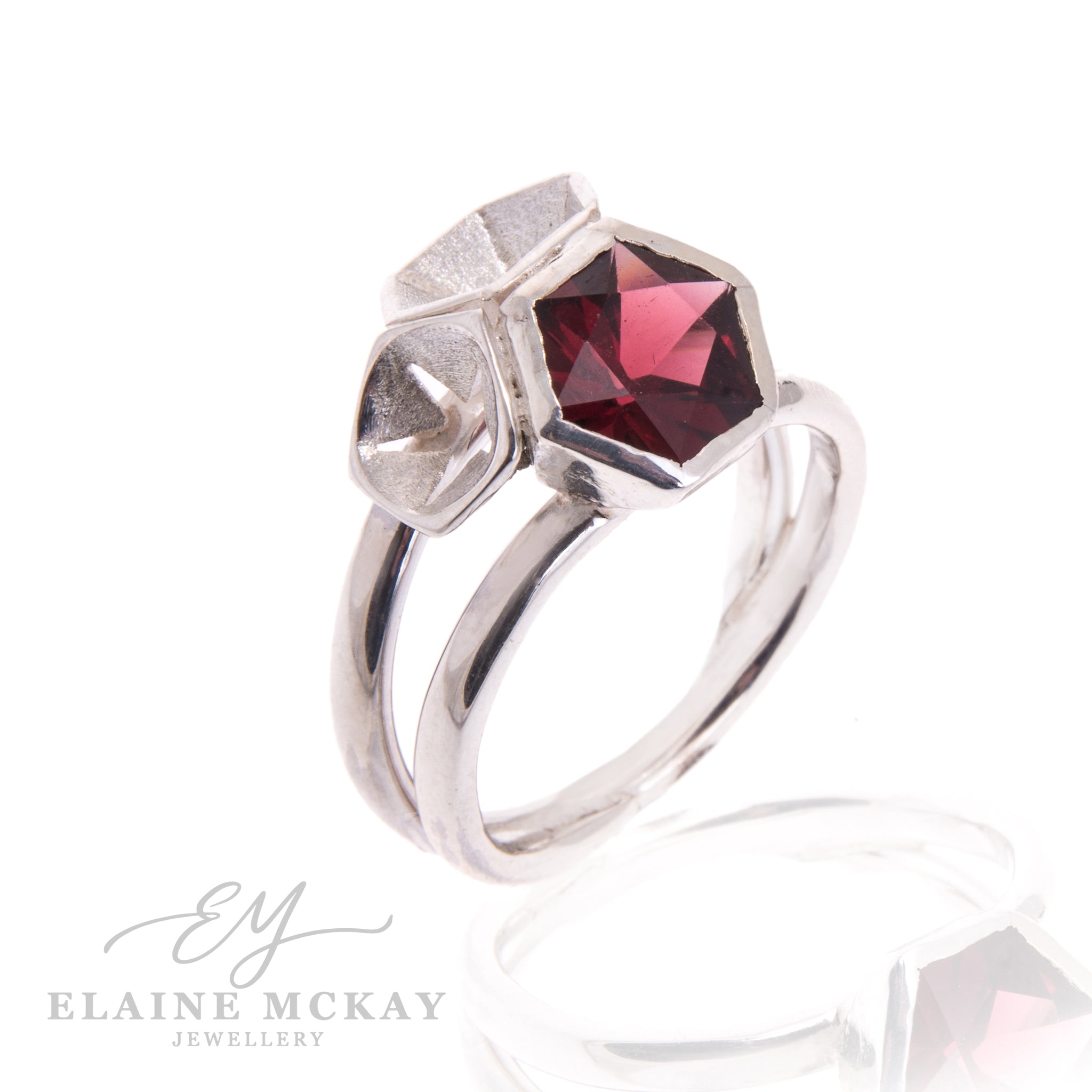 Silver ring with a red gemstone on a white background, branded 'Elaine McKay Jewellery'.