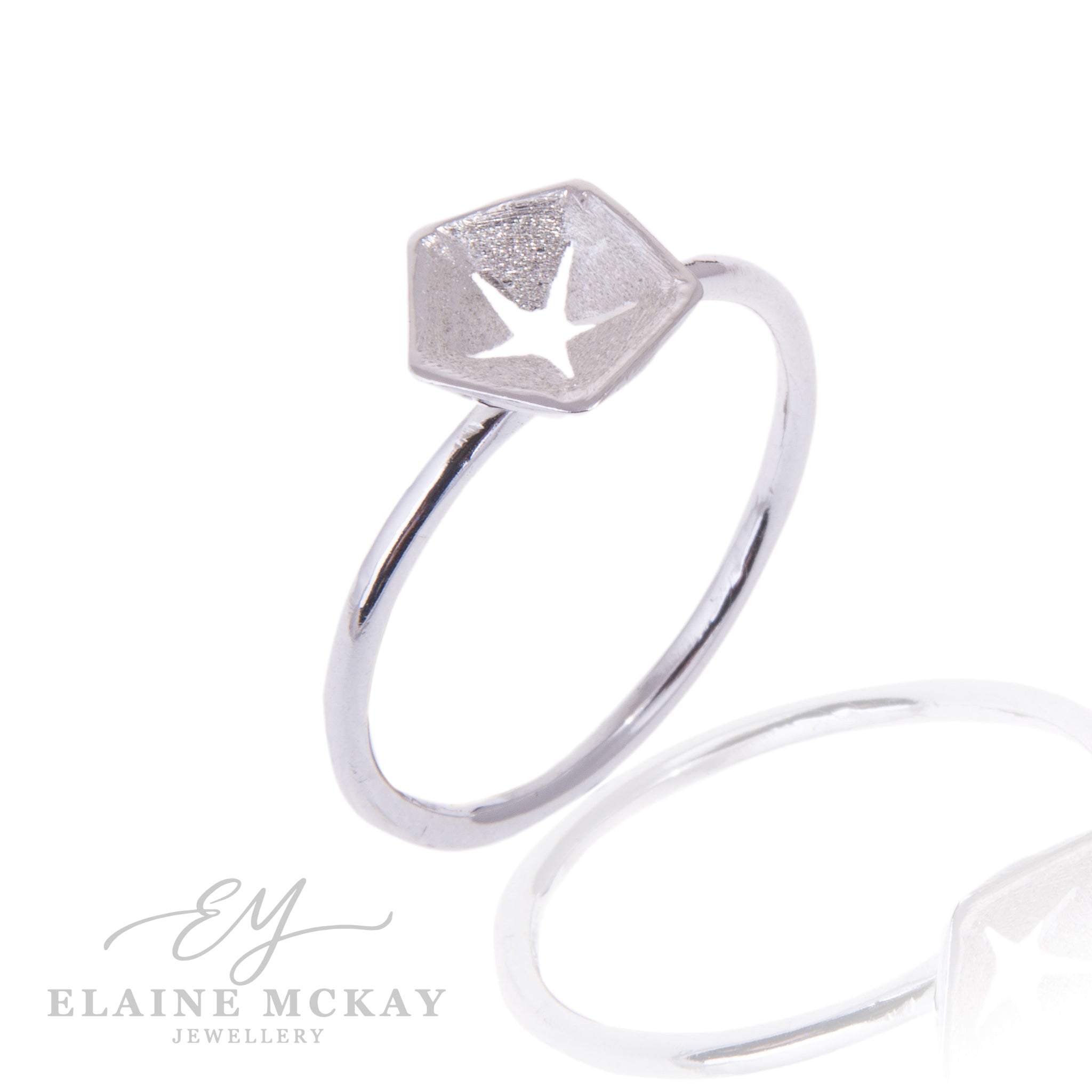 Hex silver ring with a star pierced out of center on a white background