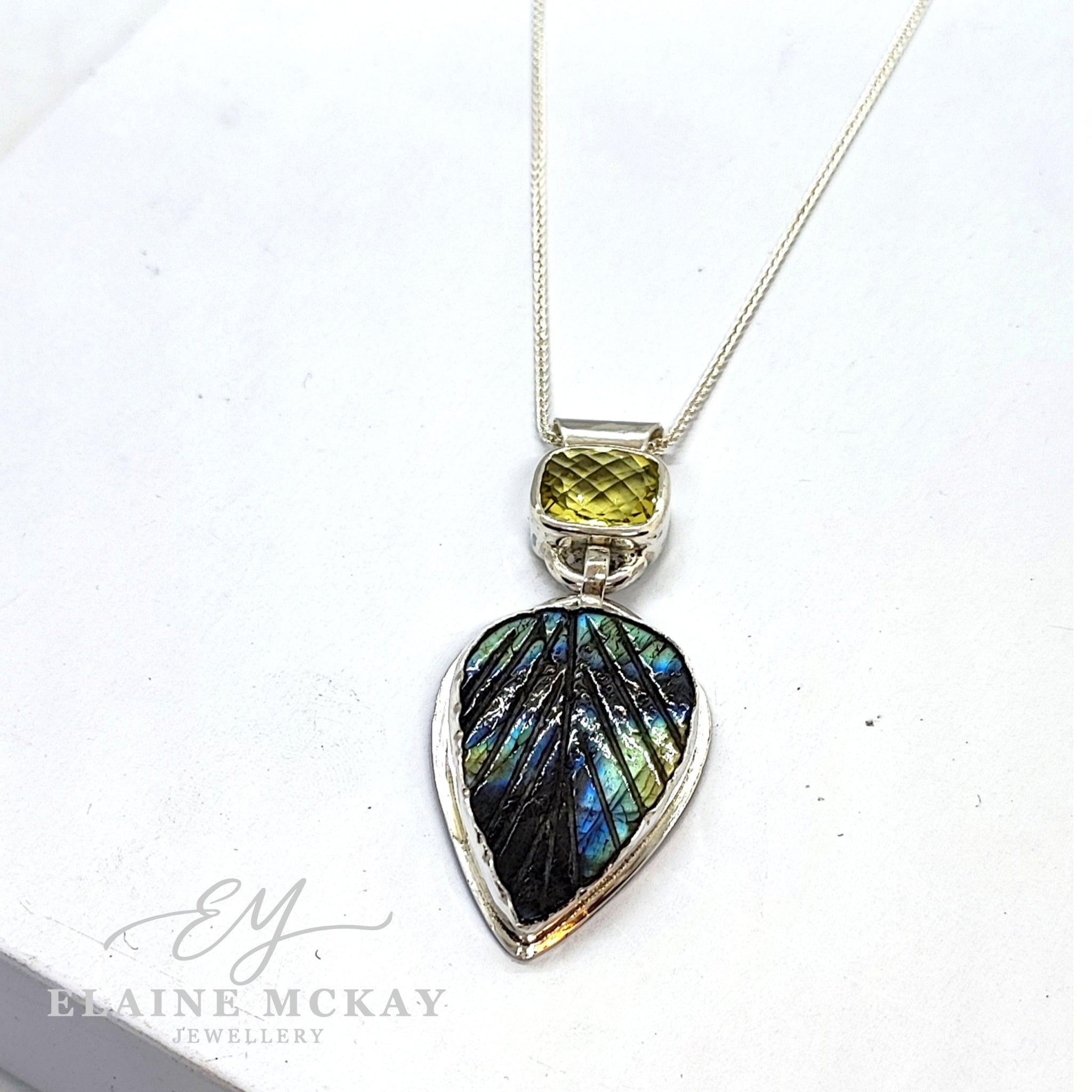 Lemon quartz and carved Leaf Labradorite pendant on a white background
