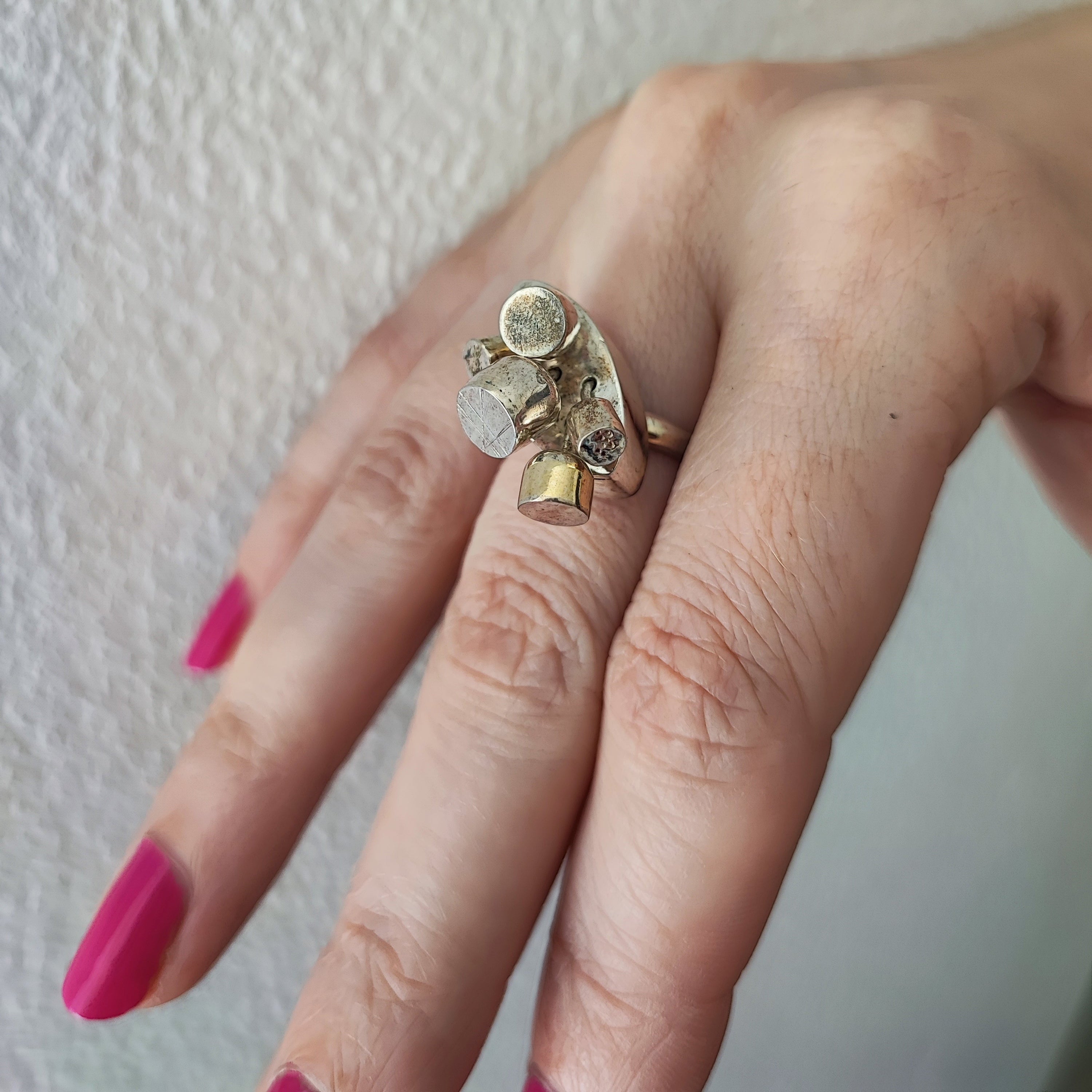 Model wearing moveable pod ring on her hand against a white background