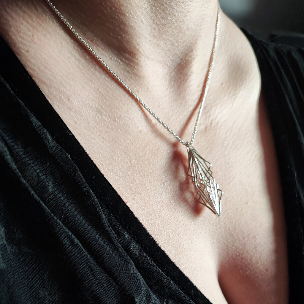 Side view of model wearing Ricard silver necklace