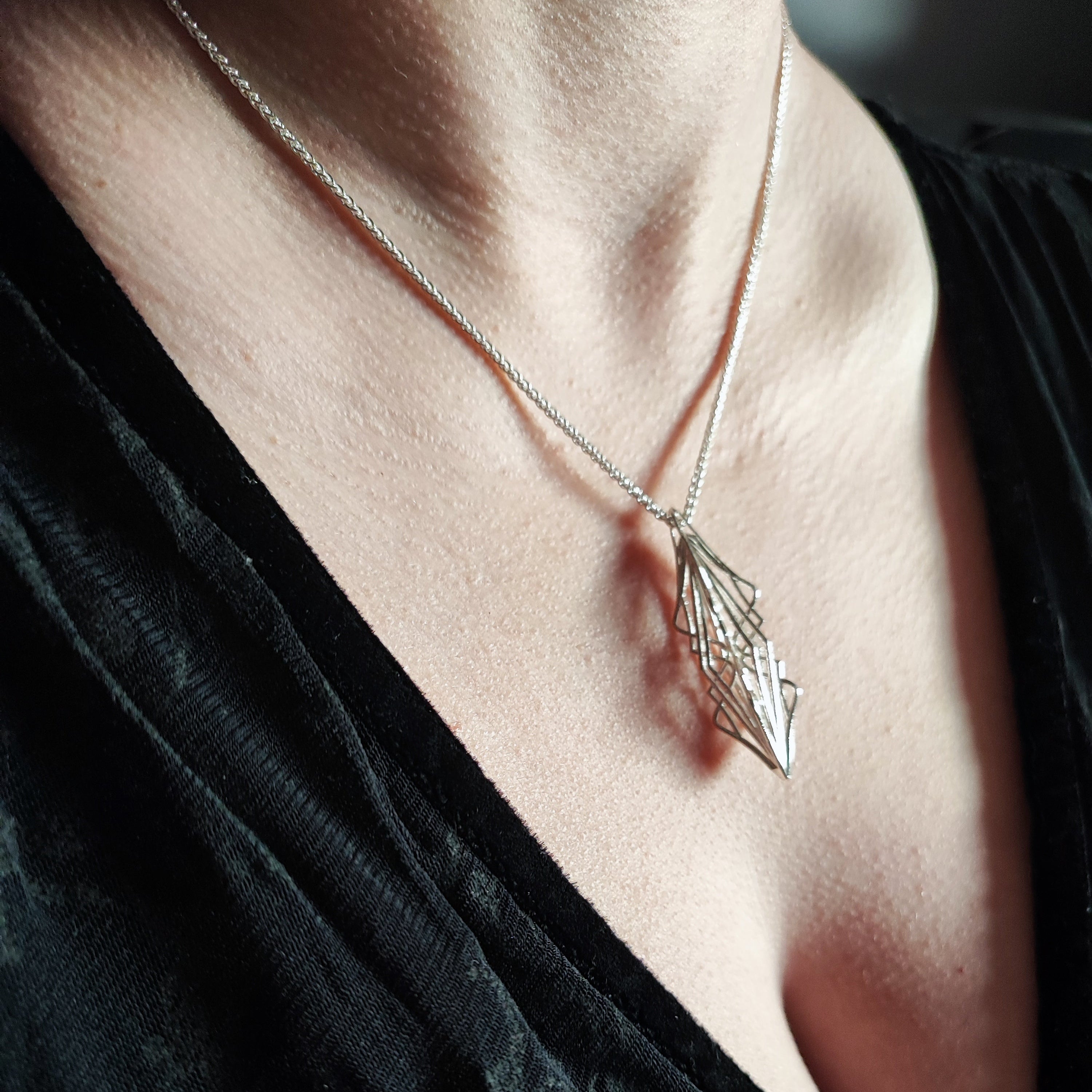 Side view of model wearing Ricard silver necklace